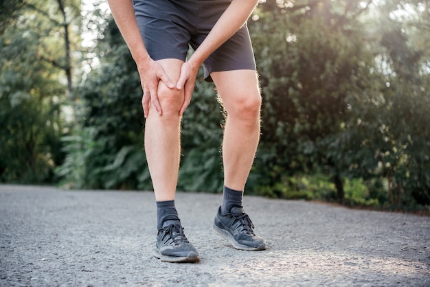 滑液包炎のために膝をまっすぐにしたり曲げたりするのが難しい男性