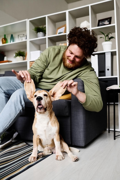 写真 彼の犬を楽しんでいる男