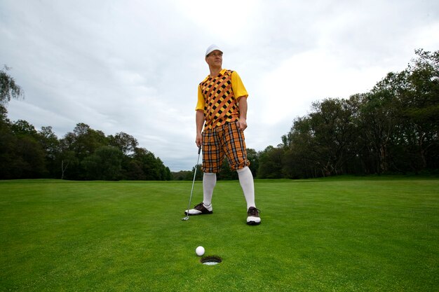 Foto uomo che ha una partita di golf all'aperto sul campo