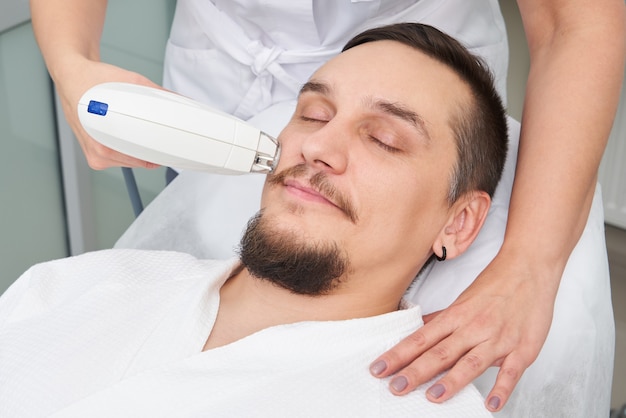 Man Having Laser Treatment At Beauty Clinic