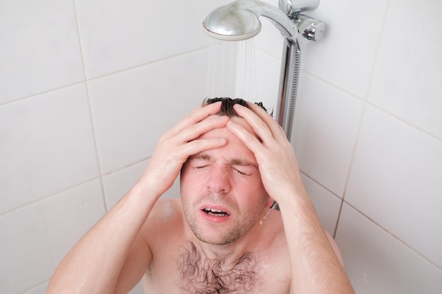 Man having a relaxing shower after hard day