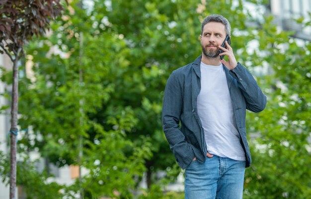 Man having smartphone call in the street with copy space man call on smartphone outside