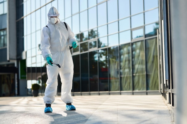 Man in hazmat suit disinfecting city streets during coronavirus pandemic