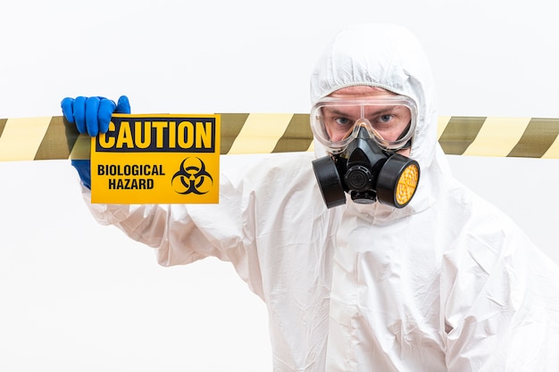 Photo man in hazmat suit with danger sign