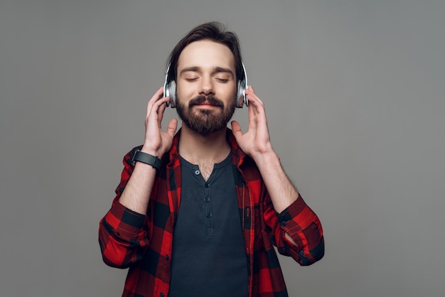 Un uomo in cuffia ascolta attentamente la musica.