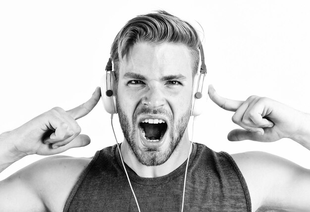 Foto l'uomo in cuffie rilassa la playlist sexy uomo muscoloso ascolta musica dalla playlist l'uomo si rilassa in auricolari isolati su bianco l'uomo con la barba lunga si rilassa con la canzone preferita