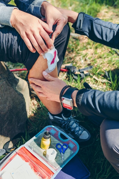 Man healing knee to woman who has been injured trekking