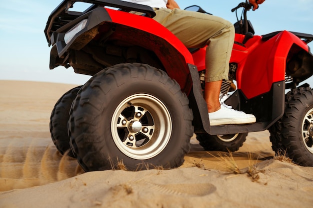 Man in helmet rides on atv in desert, action view