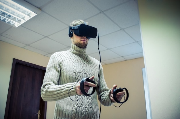 Photo man in a helmet virtual reality plays a game