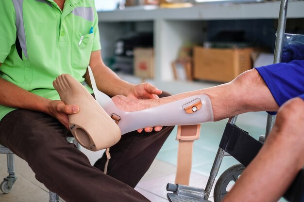 a man help disabled make new prostheses for walking in the hospital.