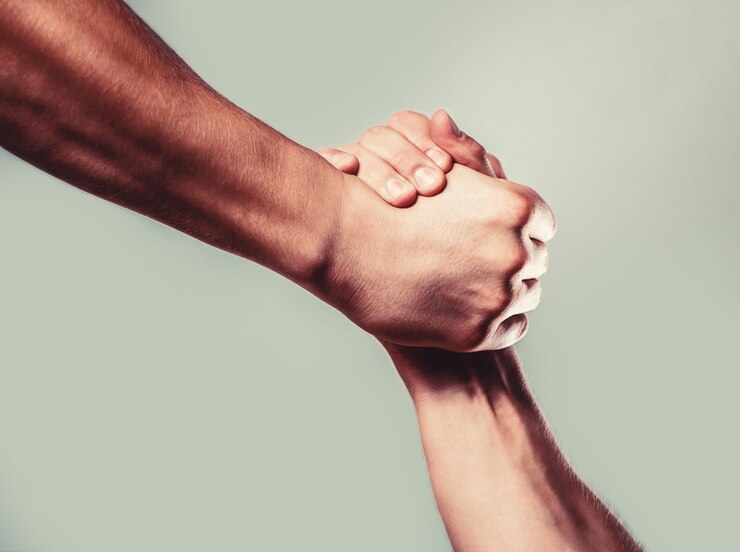 Foto man help handen, voogdij, bescherming. twee handen, geïsoleerde arm, helpende hand van een vriend. vriendelijke handdruk, vrienden begroeten. redding, helpende hand. mannenhand verenigd in handdruk.