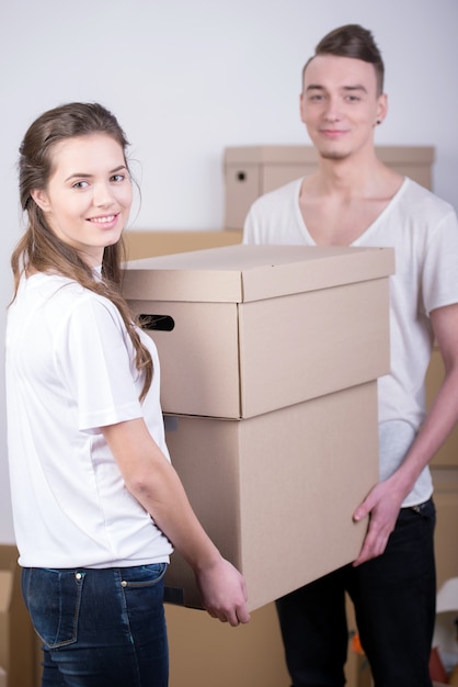 A man helps a girl carry boxes to a new home.