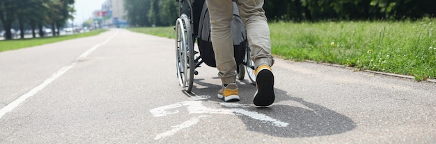 Man helpt gehandicapte persoon in rolstoel om op de stoep te lopen