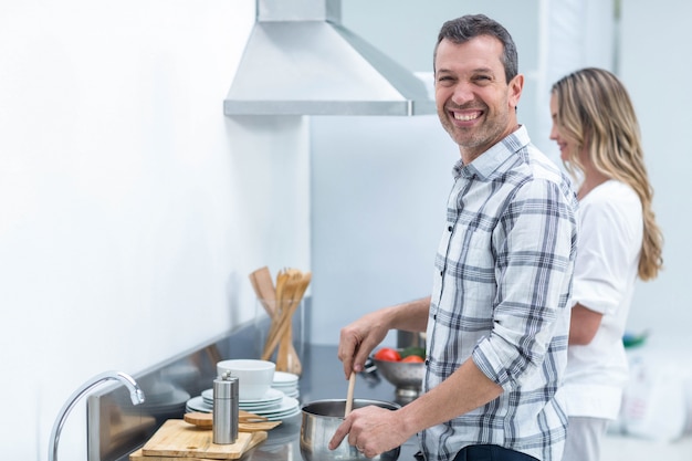 Man helpt zwangere vrouw bereiden voedsel in de keuken