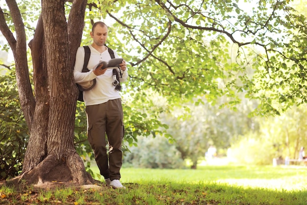 A man hides in the shade of trees on a hot day. lunch break.
rest in the middle of the working day.