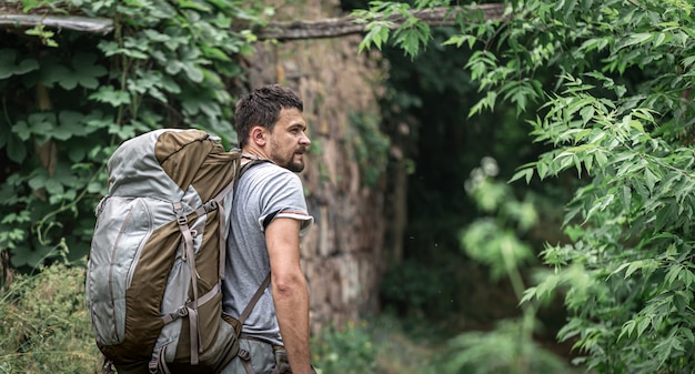 A man on a hike with a large backpack travels in the forest.