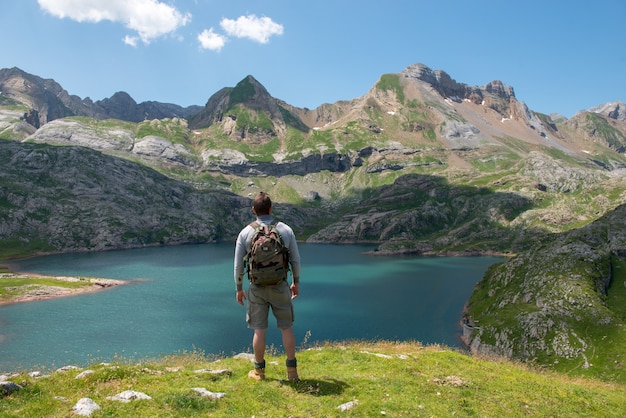 Man hiker resting and  looking at lake in the Pyrenees mountains