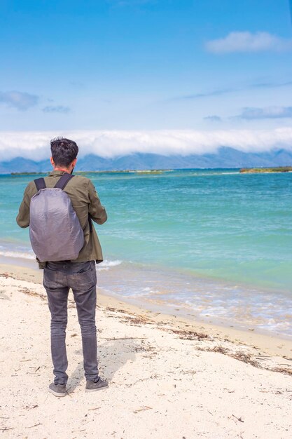 Photo man hiker standing near beautiful lake