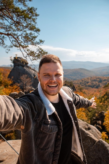 Man hiker taking selfie on the top of dovbush rocks Ukraine