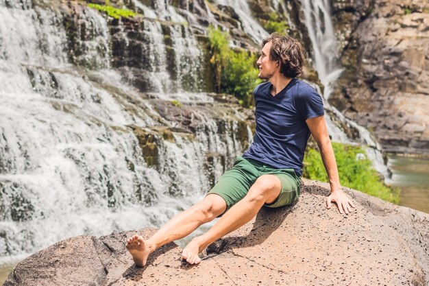 Man hiker tourist on the background of amazing pongour waterfall is famous