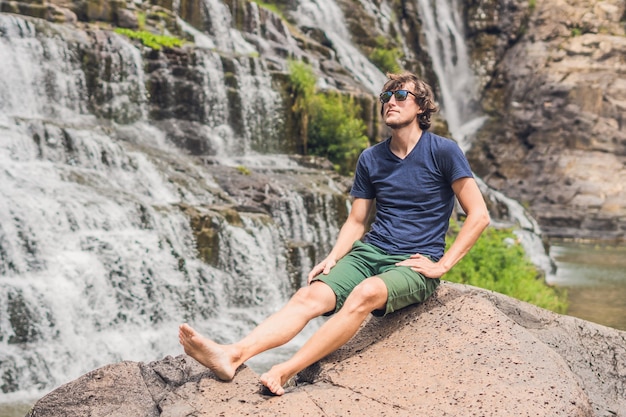 Man hiker, tourist on the surface of Amazing Pongour Waterfall is famous and most beautiful of fall in Vietnam