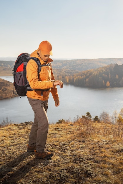 夕暮れ時の山でのハイキングのバックパックを持って旅行する男性ハイカー 垂直方向の画像