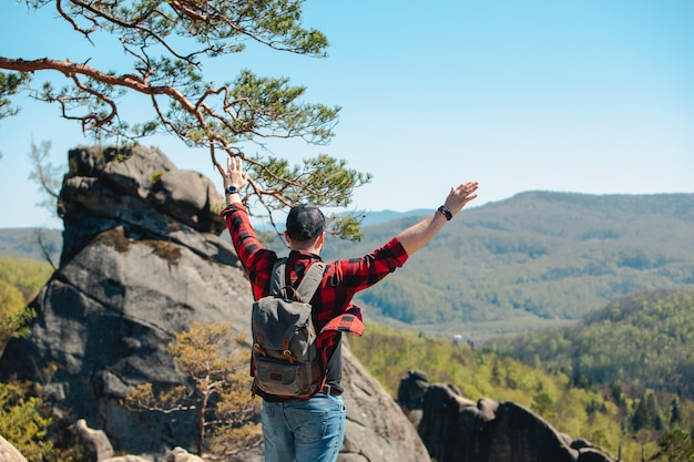 Man hiker with backpack at dovbush rocks landscape