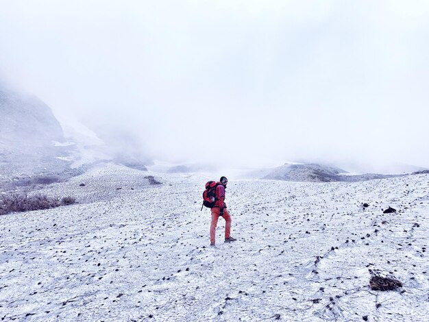 Photo man hiking on snow covered land