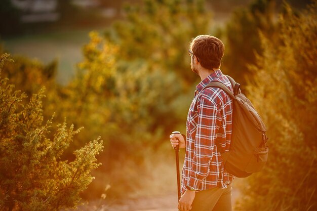 Man hiking at sunset mountains with backpack