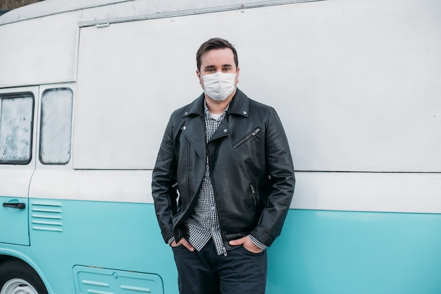 Man hipster medische masker dragen op schattige retro auto