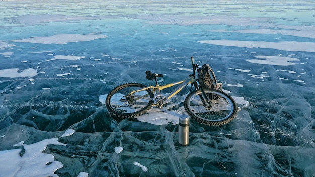 男と彼の自転車の氷と自転車のバックパック凍ったバイカル湖の氷