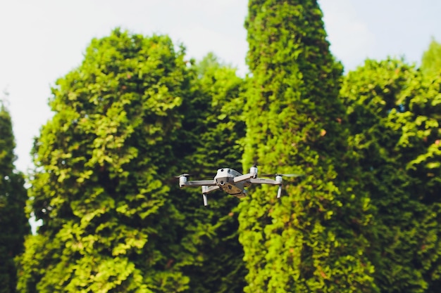 man and his drone quadrocopter in a forest on a green background