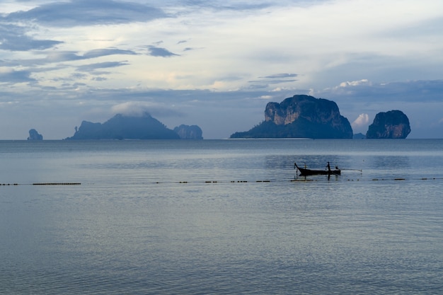 タイ、クラビ、ライレイのプラナン洞窟ビーチで美しい朝の光を浴びながら朝の魚から戻ってきた漁船の男