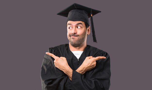 Man on his graduation day University pointing to the laterals having doubts