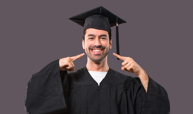 Uomo nel suo giorno di laurea università sorridente con un'espressione felice e piacevole