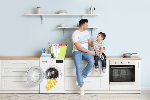 Man and his little son doing laundry at home