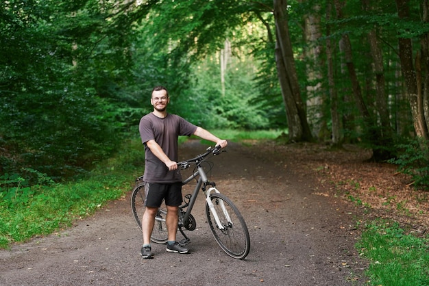 Мужчина на своем горном велосипеде на открытом воздухе Молодой байкер в сельской местности
