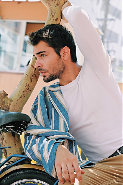 Foto un uomo sul suo posto stanco mentre è seduto accanto alla sua bicicletta