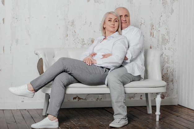 a man and his wife in white shirts in a photo studio