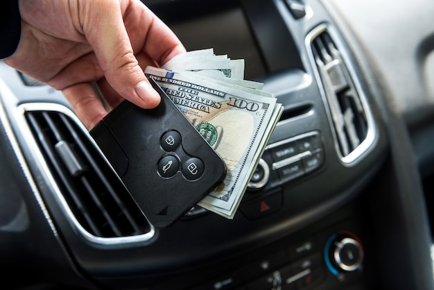 Man hold dollar and car key for pay rent or bribe. finance