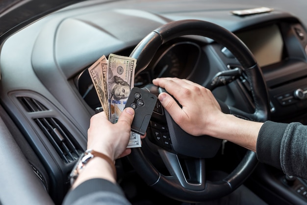 Man hold dollar and car key for pay rent or bribe