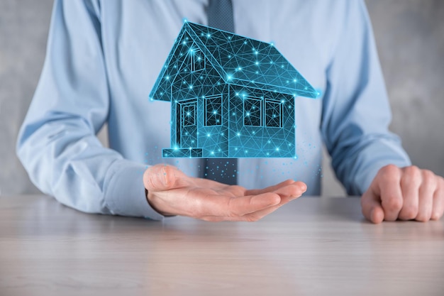 Man hold low polygon.Real estate concept, businessman holding a house icon.House on Hand.Property insurance and security concept. Protecting gesture of man and symbol of house