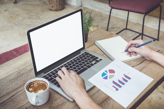 man hold pencil and using laptop on table with coffee