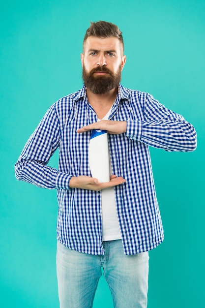 Foto bottiglia di shampoo della stretta dell'uomo. lo shampoo e il balsamo che scegli possono fare la differenza nei capelli a partire dalle radici. igiene personale. cura dei capelli. shampoo per uso quotidiano. bagno doccia cosmetico per la cura del corpo.