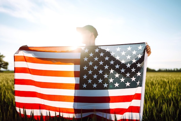 Man hold waving american USA flag Patriot raise national american flag Independence Day 4th July