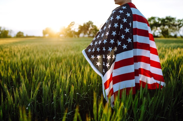 Man hold waving american USA flag Patriot raise national american flag Independence Day 4th July