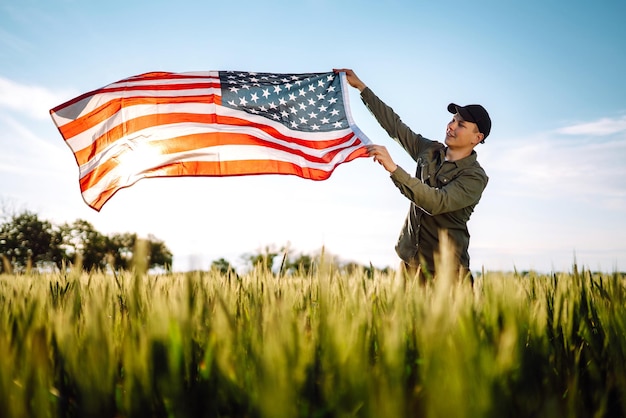 Man hold waving american USA flag Patriot raise national american flag Independence Day 4th July