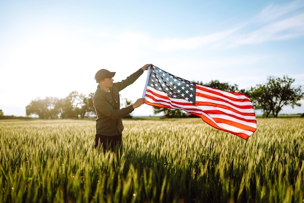 Man hold waving american USA flag Patriot raise national american flag Independence Day 4th July