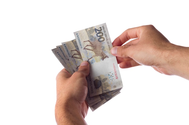 Man holding 200 reais bills isolated on white. Brazilian money. paying.