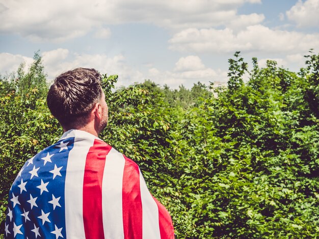 Uomo che tiene una bandiera americana. festa nazionale